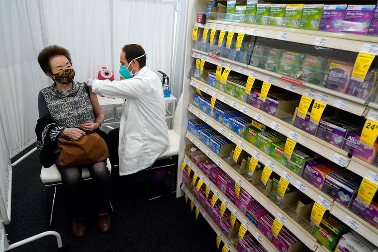 Pharmacist Todd Gharibian, right, administers a dose of the Moderna COVID-19 vaccine to Toshiko Sugiyama, left, at a CVS Pharmacy branch Monday, March 1, 2021, in Los Angeles.