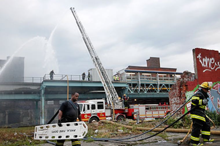 Philadelphia firefighters battled a multi-alarm warehouse blaze along North Front Street, just below Girard Avenue in the Fishtown section of the city, early Tuesday. This picture shows them gathering up their equipment. (Alejandro A. Alvarez / Staff Photographer)