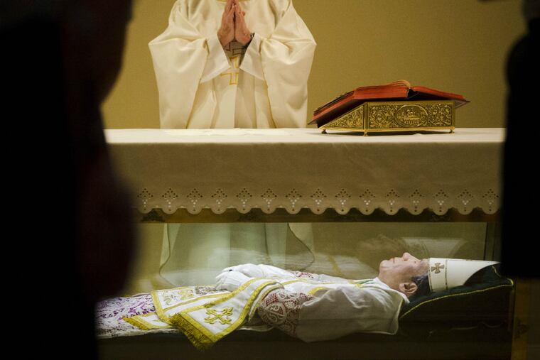 In this Tuesday, May 5, 2015 file photo, the Rev. John McLoughlin, Pastor of Our Mother of Perpetual Help in Ephrata, Pa., prays over the remains of Saint John Neumann at the national shrines of St. John Neumann in Philadelphia. The site is one of the most important Catholic heritage sites in the city, which will host a visit from the Pope in late September 2015. (AP Photo/Matt Rourke)