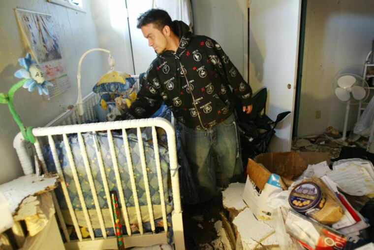 Martin Rojas checks his son's crib Christmas morning after a fire drove him and his family from their Kensington apartment.