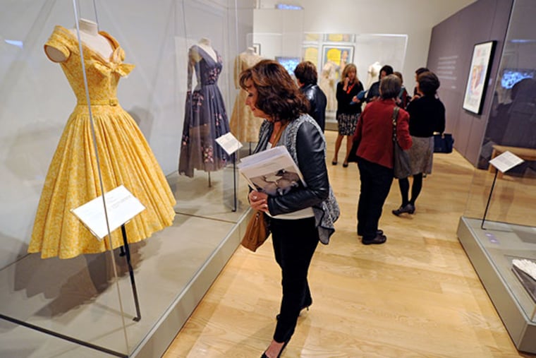 Rose Hurley, 60, Holland, a docent at the James Michener Museum, admires a gown of Grace Kelly's shown in the Grace Kelly exhibit at the museum Oct. 28, 2013. The docents attended a class on the exhibit before the official opening at 10 a.m., then they wandered the exhibit on their own to learn more. ( CLEM MURRAY / Staff Photographer )