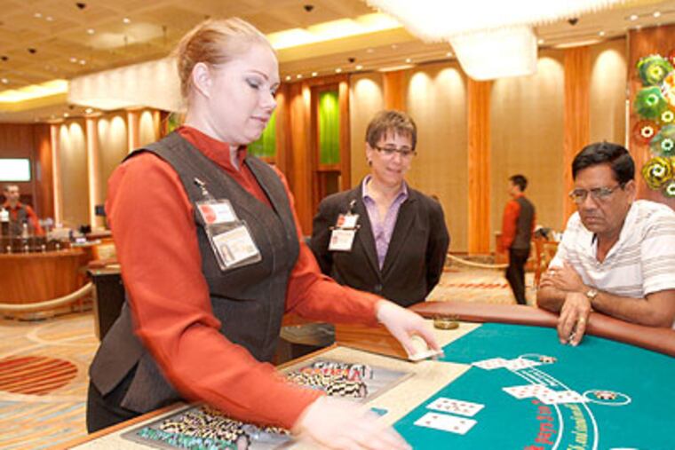 Parx Casino, the state's top grossing casino, is introducing a custom-designed, private High Limit Room. In it, Jessica Baxter, left, deals blackjack to customer Vipin Patel while floor supervisor Deborah Suppa watches. (Charles Fox / Staff Photographer)