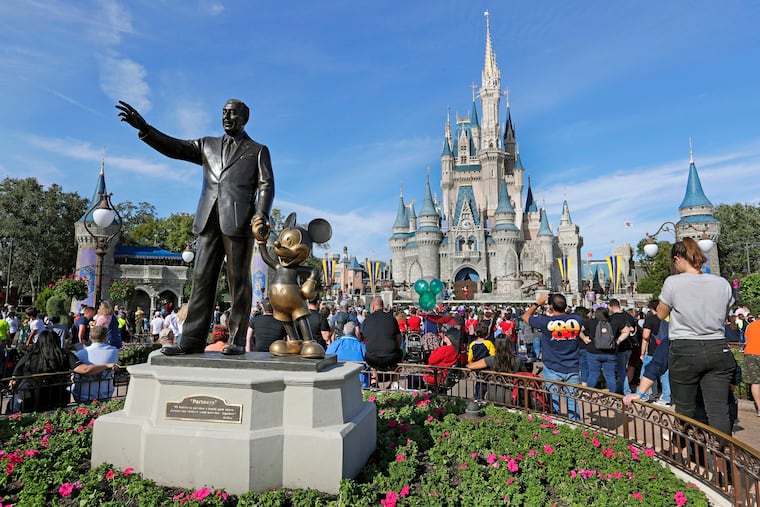 In this Jan. 9, 2019, file photo, guests watch a show near a statue of Walt Disney and Mickey Mouse in front of the Cinderella Castle at the Magic Kingdom at Walt Disney World in Lake Buena Vista, Fla.