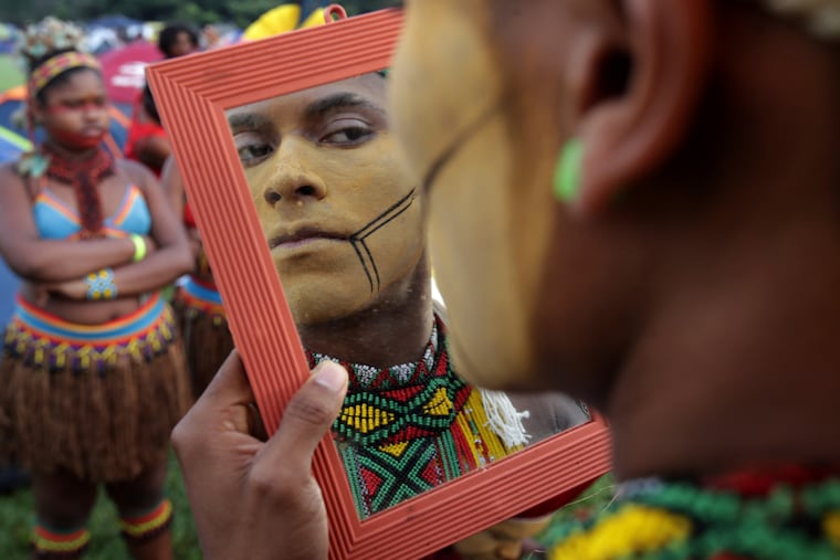 A young indigenous man applies body paint as he checks himself out in a mirror, during an annual three-day campout protest known as the Free Land Encampment, in Brasilia, Brazil, Wednesday, April 24, 2019. The event begins amid animosity between Brazil’s indigenous groups and the new government of far-right President Jair Bolsonaro. (AP Photo/Eraldo Peres)