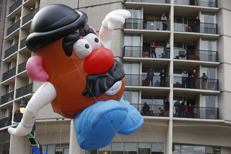Hotel guests at Embassy Suites near 18th and Ben Franklin Parkway watch as a Mr. Potato Head balloon makes its way up the Ben Franklin Parkway during the Thanksgiving Day Parade in 2016.