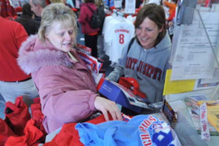 Stacking their Phillies gear at the checkout counter of the Modell's in Clifton Heights are Kate Cornell (left) and Debbie Maguire, both of Drexel Hill. Fans throughout the area snapped up memorabilia.