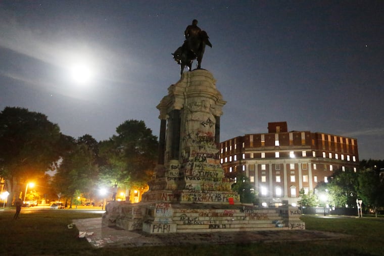 The moon illuminates the statue of Confederate General Robert E. Lee on Monument Avenue in Richmond, Va.