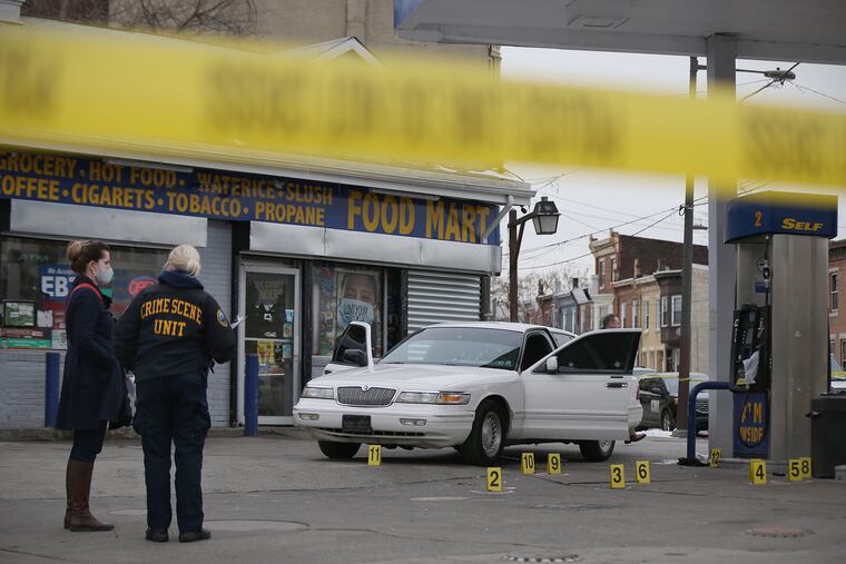 Philadelphia police investigate a fatal shooting at the gas station at 33rd and York Streets in Philadelphia's Strawberry Mansion section on Friday, Feb. 12, 2021. Police said a 38-year-old man was shot six times at 1:50 p.m. and taken to Temple University Hospital, where he was pronounced dead.