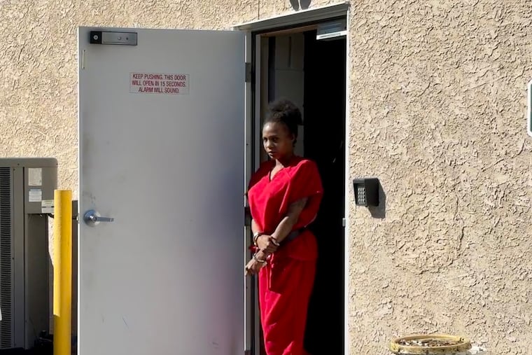 Evelena Williams is escorted out of district court in Glenolden on Wednesday after her preliminary hearing on murder and related crimes. Williams is accused of killing Latoya Davis during an argument outside of a Wawa.