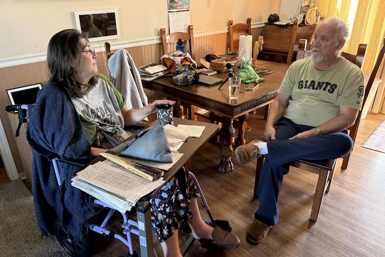 Jean Franklin, left, and her husband, Chaz, talk at the kitchen table of their home in Colusa, California. In January, Chaz’s health insurance premium payment increased sevenfold after enhanced federal tax credits expired. (Christine Mai-Duc/KFF Health News)