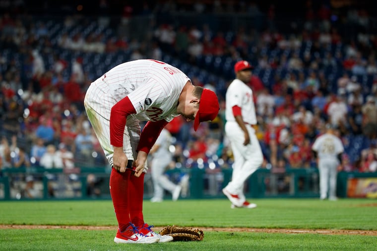 Rhys Hoskins adjusts his uniform after committing a key error during the ninth inning Tuesday night.