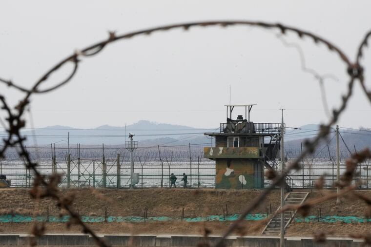 South Korean army soldiers patrol along a barbed-wire fence in Paju, near the border with North Korea.