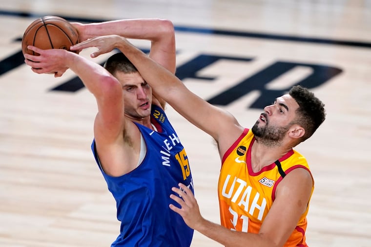 Denver Nuggets' Nikola Jokic (15) keeps the ball from Utah Jazz's Georges Niang (31) during the first half of an NBA basketball first round playoff game Sunday, Aug. 30, 2020, in Lake Buena Vista, Fla.