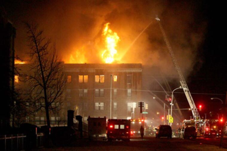 A fire in an apartment building on Walnut St. between 48th and Hanson streets burned into the evening. (Charles Fox / Staff Photographer)