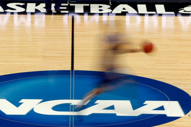 In this March 14, 2012, file photo, a player runs across the NCAA logo during practice at the NCAA tournament college basketball in Pittsburgh. The NCAA Board of Governors took the first step Tuesday toward allowing athletes to cash in on their fame.