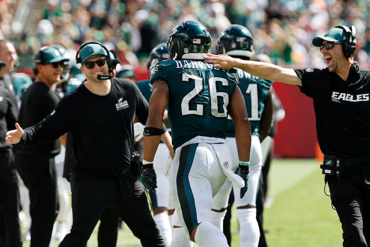 Offensive coordinator Kevin Patullo taps running back Saquon Barkley after the Eagles scored a touchdown last Sunday.