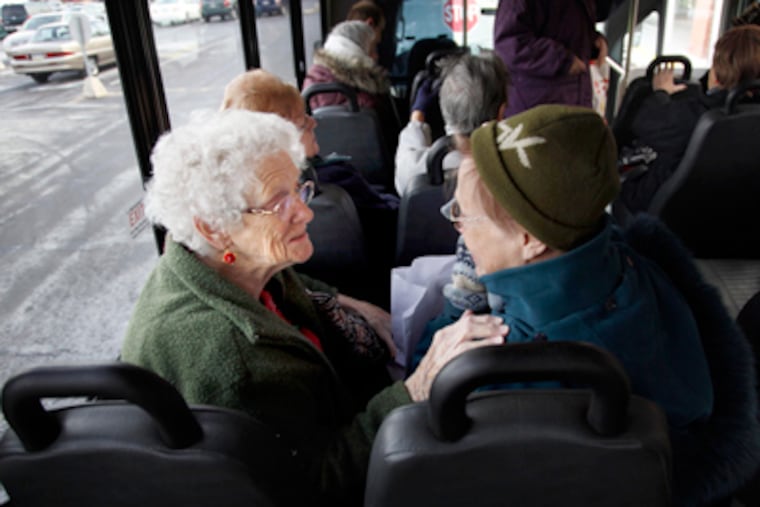 Emily Wilkinson (left) and Helene Basas greet each other as they find their seats on Abington's fixed-route bus for senior citizens. (Laurence Kesterson / Staff Photographer)