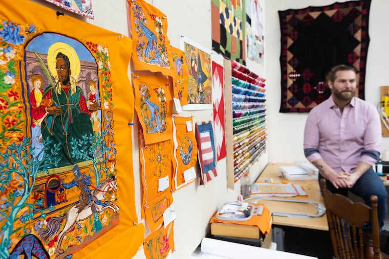 Artist Jesse Krimes pictured June 8, 2023. In the foreground (left) is a work from a previous project showing an incarcerated individual embroidered in a medieval style.