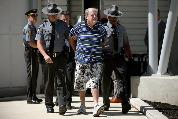In a file photo from Tuesday, Sept. 3, 2019, Pennsylvania state troopers lead Theodore Dill Donahue out of the Pennsylvania State Police Troop K barracks in West Philadelphia after arresting him as a suspect in the 1991 murder of Denise Sharon Kulb.