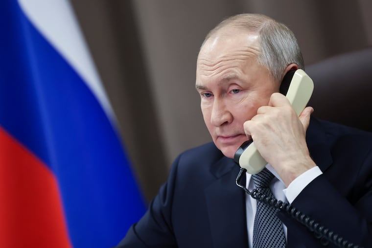 Russian President Vladimir Putin speaks on the phone with a girl from the Moscow region, as part of a Christmas charity campaign in St. Petersburg, Russia, Dec. 26, 2024.