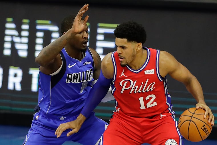 Sixers forward Tobias Harris dribbles the basketball against Dallas Mavericks forward Dorian Finney-Smith on Thursday. Harris left the game with a knee injury.