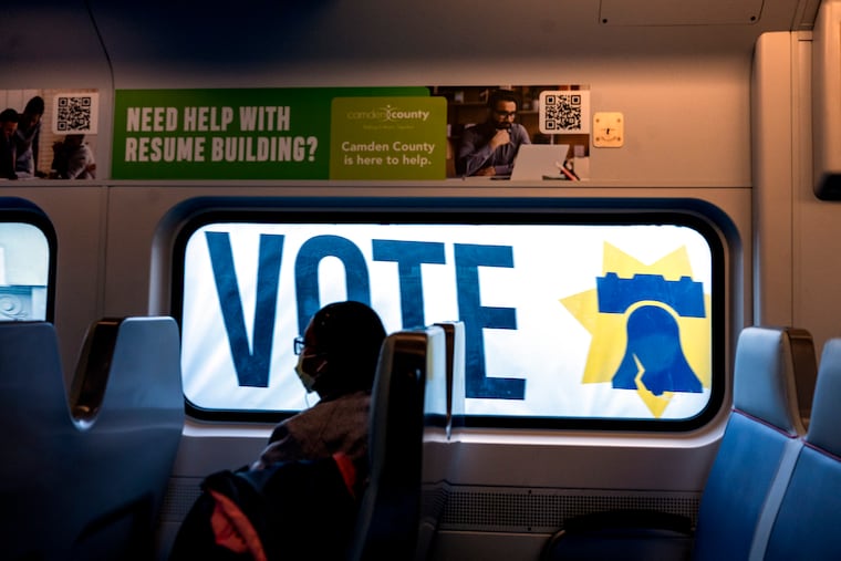 A PATCO Speedline train headed into Philadelphia from New Jersey on the Ben Franklin Bridge passes a campaign sign on the side of a building in Old City.