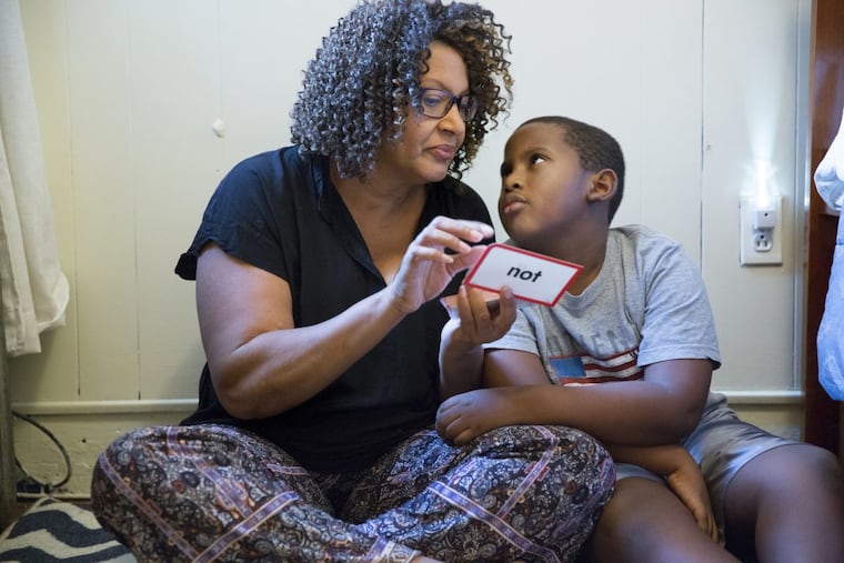 Avril Absolum uses flash cards to work with her son Jalen, who struggles to learn after being lead poisoned in his rental home.