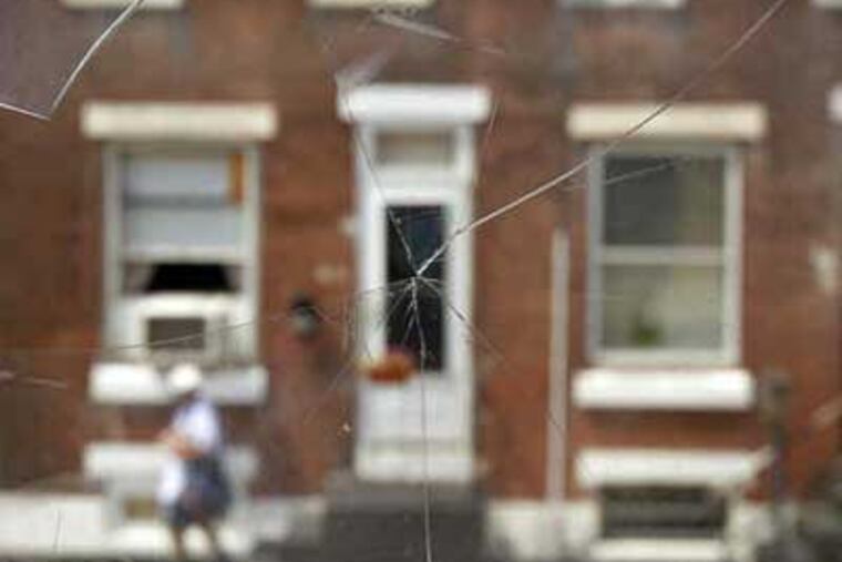 A view through an abandoned house to the 'Rocky' home on Tusculum Street. (David Maialetti / Staff Photographer)