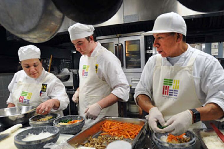 Plating vegetable bibimbap are (from left) instructor Adrienne Hall and
students Edward Green and Timothy Longstreth.