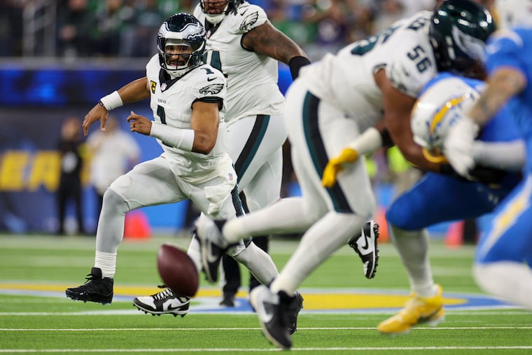 Eagles quarterback Jalen Hurts tries to pick up a fumble after the Los Angeles Chargers intercepted the ball in the second quarter on Monday night.