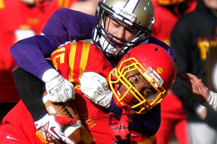 Haverford High's Jai Thornton gets taken down by Upper Darby's Justin Vendetti after making an interception that set up a second-quarter Fords touchdown. The host Fords defeated Upper Darby, 31-13, Thursday in a Thanksgiving Day and Central League football game. (Lou Rabito/Staff)