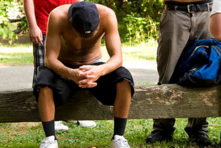 After hours of searching Pennypack Creek, friends of Saulius Kvaraciejus rest after finding his body about a mile from the waterfall where he was last seen, struggling in the torrent.