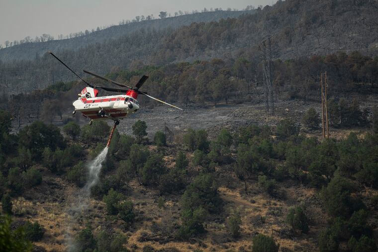 A Chinook helicopter fills up with water to release on the Lake Christine Fire, Saturday, July 7, 2018 in Basalt, Colo.