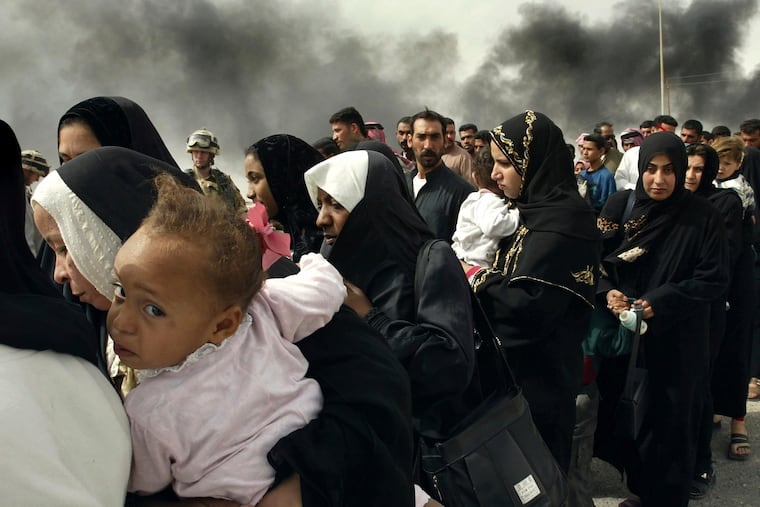 Iraqi women line up for a security check by British soldiers on the outskirts of Basra, as they try to flee from this southern Iraqi town on March 30, 2003.