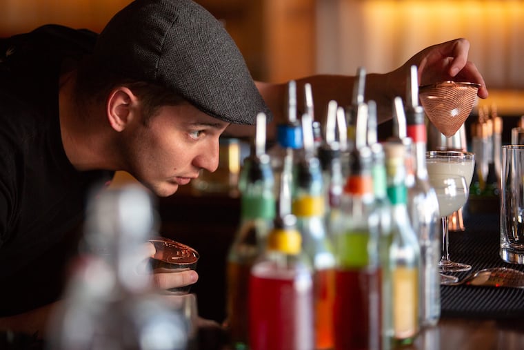Aaron Deary pours a drink into a glass of ice at R&D Cocktail bar in Fishtown, Philadelphia, Thursday, January 31, 2019. Clear ice does not melt as quickly as broken, white, ice.