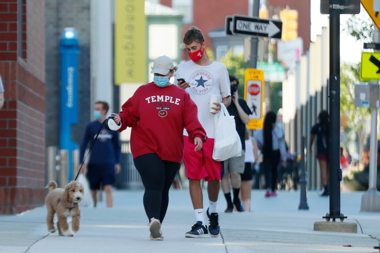Temple student Lauren Marhefka and her 3-month-old golden doodle support dog “Marshmallow” on the Temple campus on Aug. 30, 2020. In-person classes at Temple have been put on hold for two weeks because after the university reopened for some on-campus instruction, its coronavirus cases spiked to over 100.