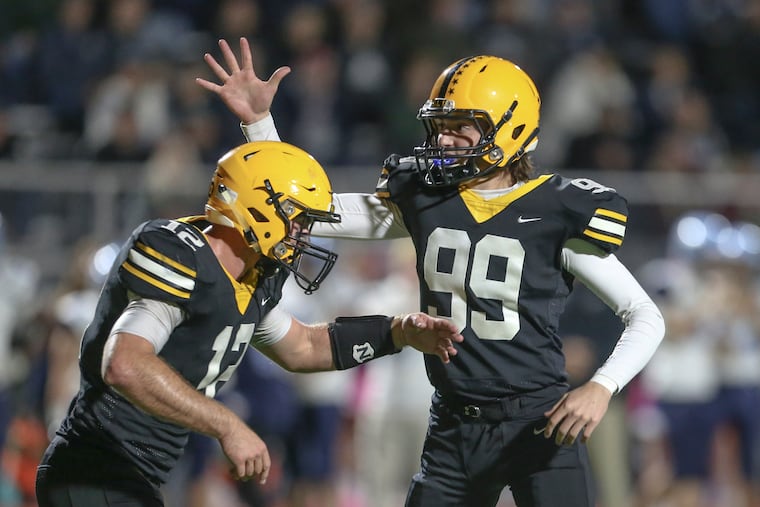 Central Bucks West kicker Bailey Moyer (99) celebrates with holder Jack Neri after the game-winning extra point in 27-26 win over North Penn on Friday night.