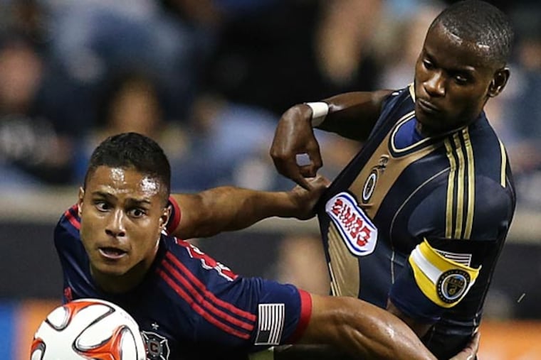 Maurice Edu (21) tries with Chicago Fire forward Quincy Amarikwa (24) for the ball during the first half of an MLS soccer game in Chester, Pa., Thursday, Oct. 2, 2014. (Steven M. Falk/Staff Photographer)