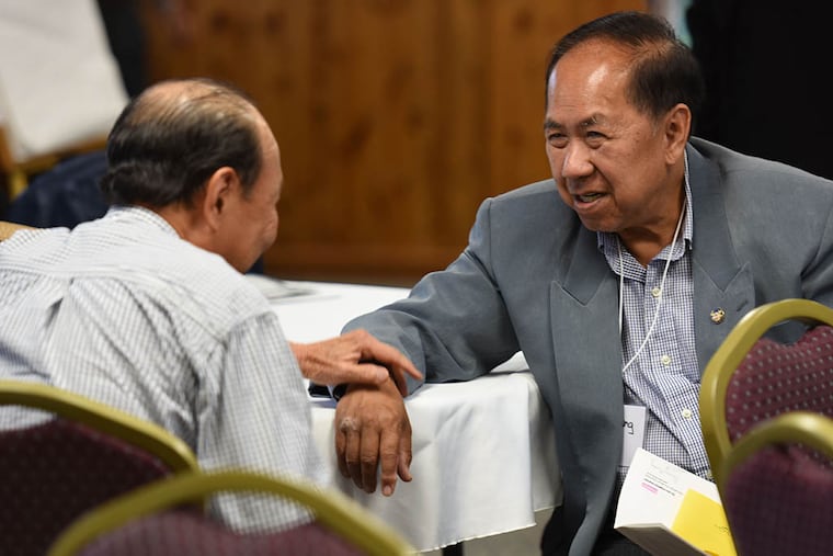 Former South Vietnamese refugees Quy Truong, left, and Duc Huang get reacquainted at their 40th reunion at Fort Indiantown Gap. (Bradley C Bower/For The Inquirer)