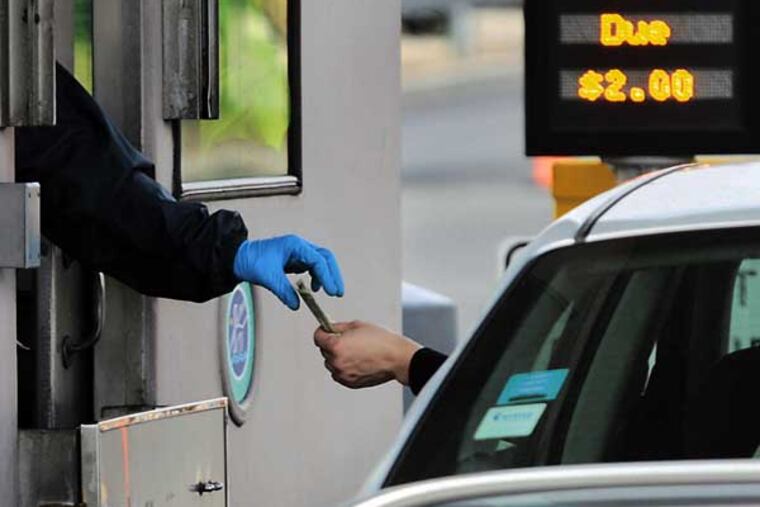 A Burlington Bristol Bridge toll collector collects the $2.00 bridge toll from a motorist on March 5, 2010. Toll collecting on both bridges is on the NJ side of the river. ( Elizabeth Robertson / Staff Photographer )