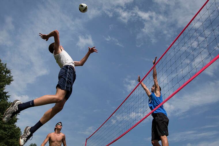 Landon Shorts, left, returns the ball on Logan Smiley during 18-and-under play at the Pottstown Rumble volleyball tournament in Manatawny Park on June 26, 2015. ( LAURENCE KESTERSON/For The Inquirer)
