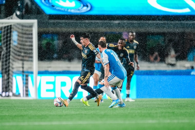 Union midfielder Jovan Lukic (left) looks to control the ball in a driving rain in Saturday's 2-1 loss to Charlotte FC at Bank of America Stadium in Charlotte, N.C.