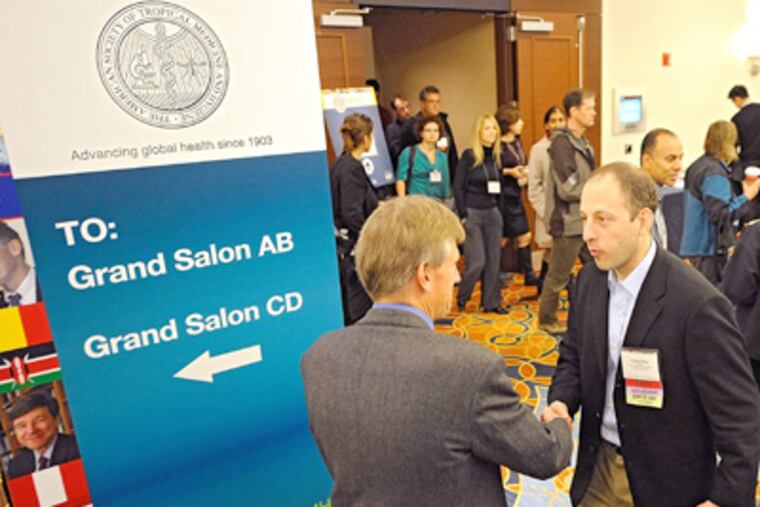 Jonathan Ripp (right) and David Mamer chat at the Marriott in Center City during the American Society of Tropical Medicine and Hygiene convention, a return to Philadelphia for the group. (Clem Murray / Staff Photographer)