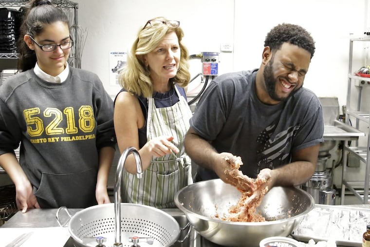 Olivia Rivera (left) looks on as Maureen Fitzgerald watches Malachi Campbell who forms the turkey meatloaf.