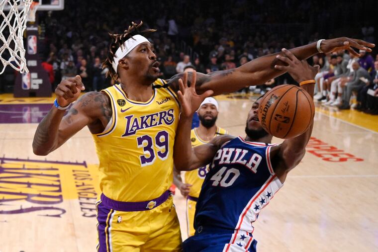 Lakers center Dwight Howard, left, blocks the shot of 76ers forward Glenn Robinson III during the first half.