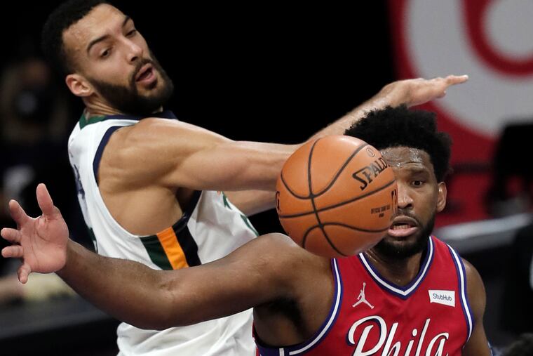 Utah’s Rudy Gobert and the Sixers' Joel Embiid eyeing a loose ball during a game last month.