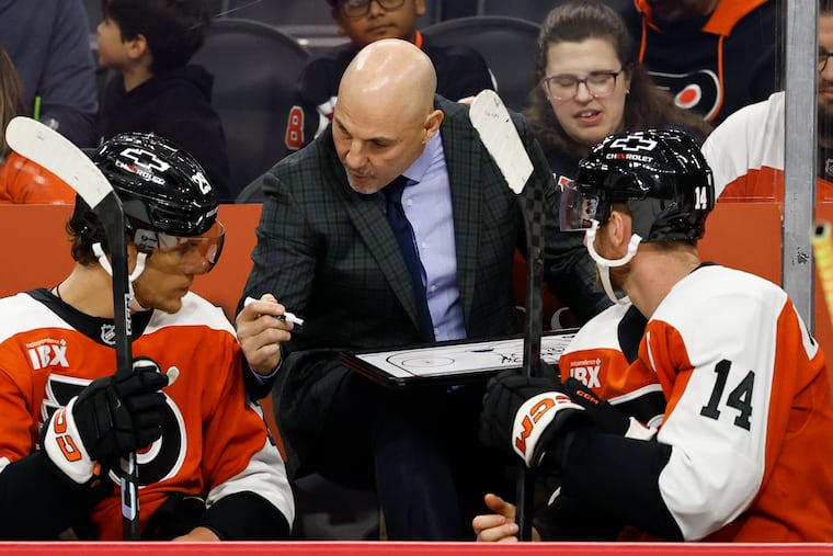 Flyers coach Rick Tocchet with center Sean Couturier (right) and right wing Nikita Grebenkin during a preseason game against the New York Islanders on Oct. 2.