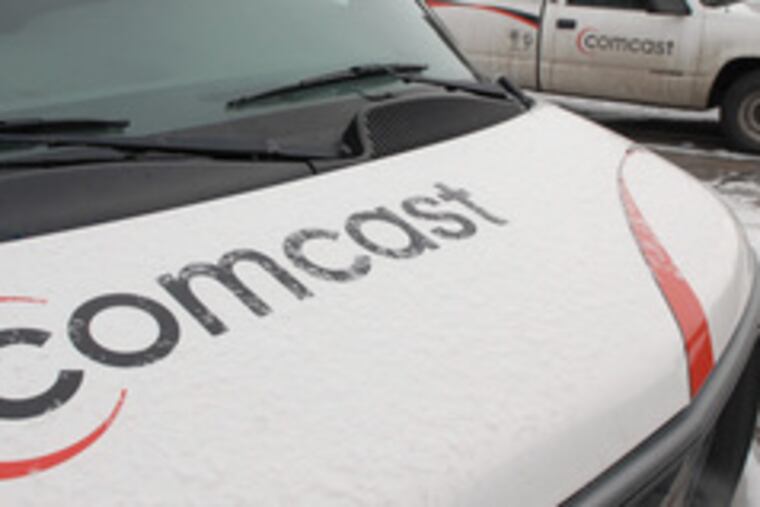 Comcast trucks line up at the cable TV giant's center in Englewood, Colo.