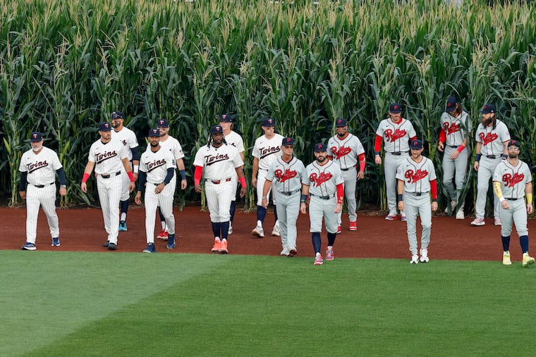 Phillies and Twins players walk on to the field from the cornfield before the start of the Field of Dreams game on Thursday in Dyersville, Iowa.