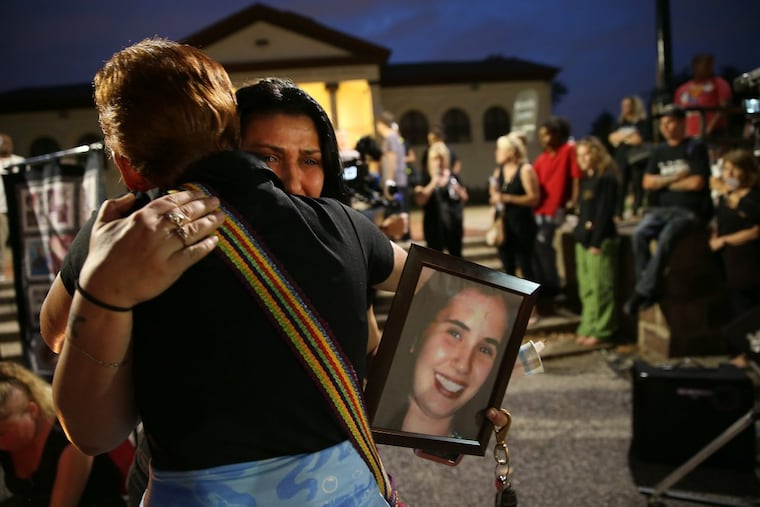 Nancy Davis, left, hugs her daughter, Darlene, as she holds a photo of her sister, Valerie, at a vigil at McPherson Square in Philadelphia on August 31, 2017. Valerie Davis died of a drug overdose at 22 in 2004.